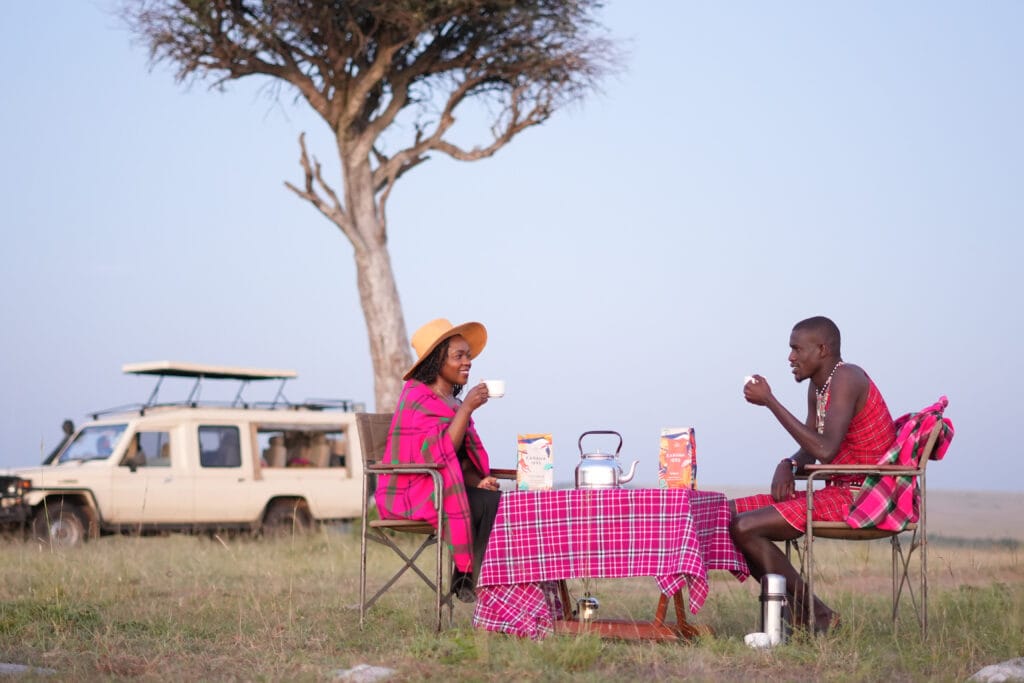 Our tour guide John, and Margaret enjoying a cup of Kahawa 1893 in the magical Maasai Mara sunrise. Photo by Billy Miaron.